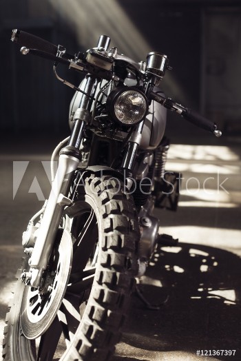 Picture of Motorcycle standing in dark building in rays of sunlight